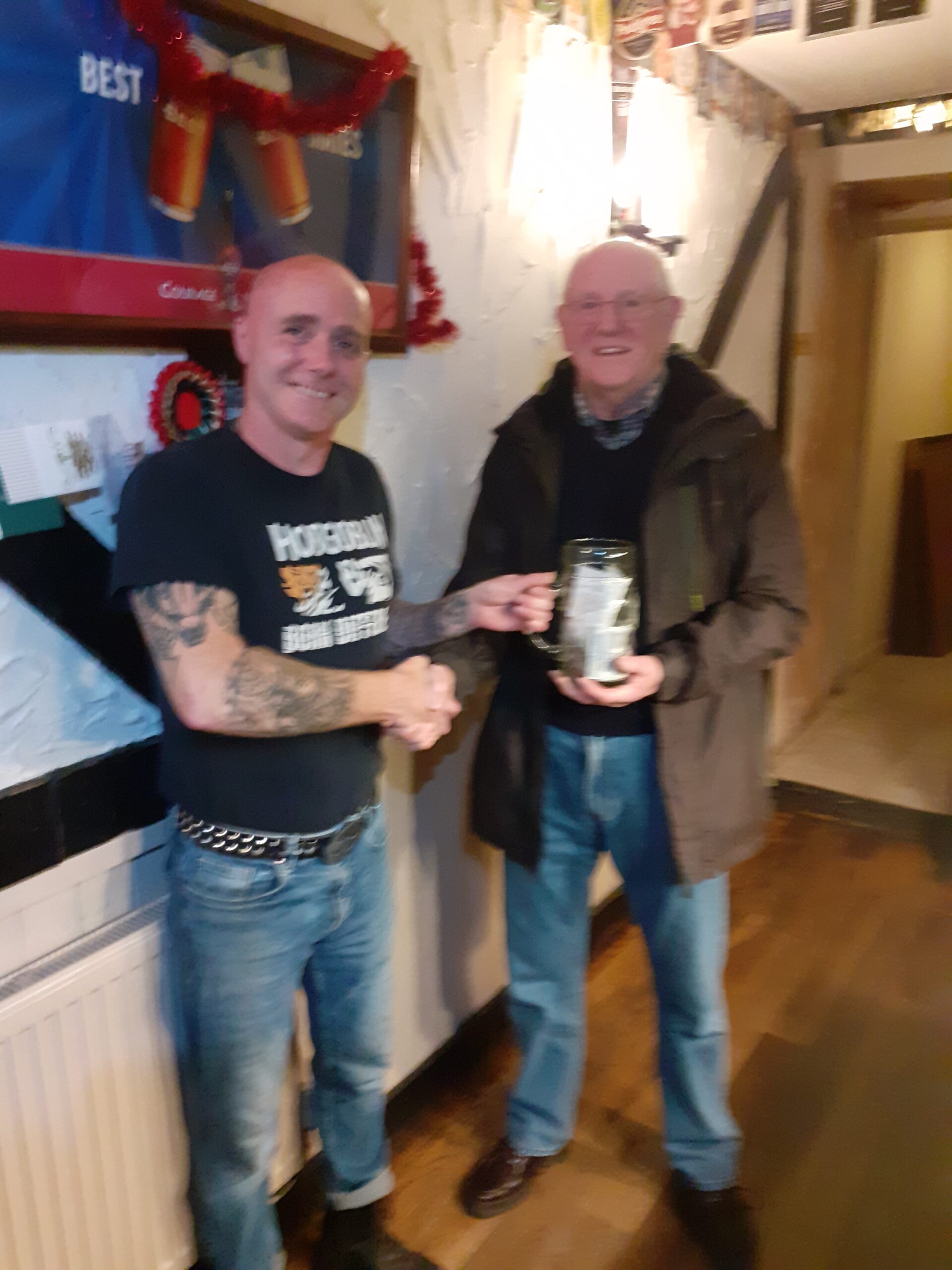 Ron being presented with a beer mug of donations from Ruby Harries.